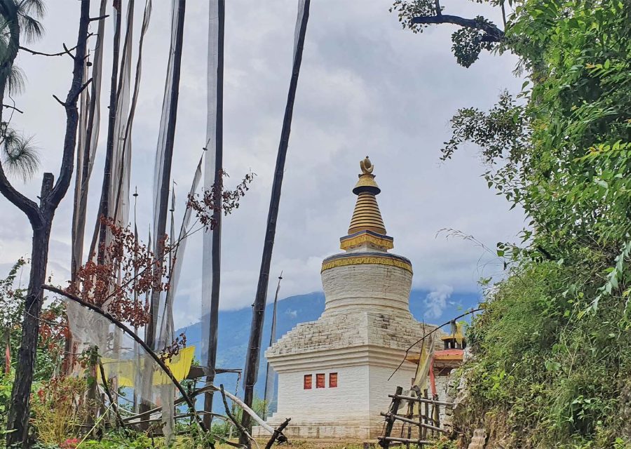 A chorten and prayer flag poles on the hillside at Mongar