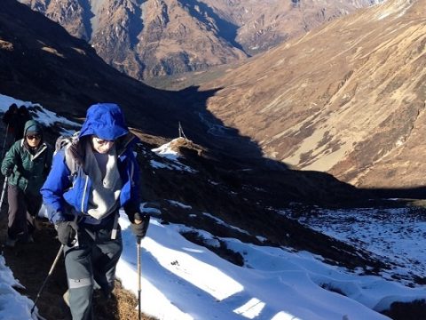 Trekkers on a high trail below the snow peaks